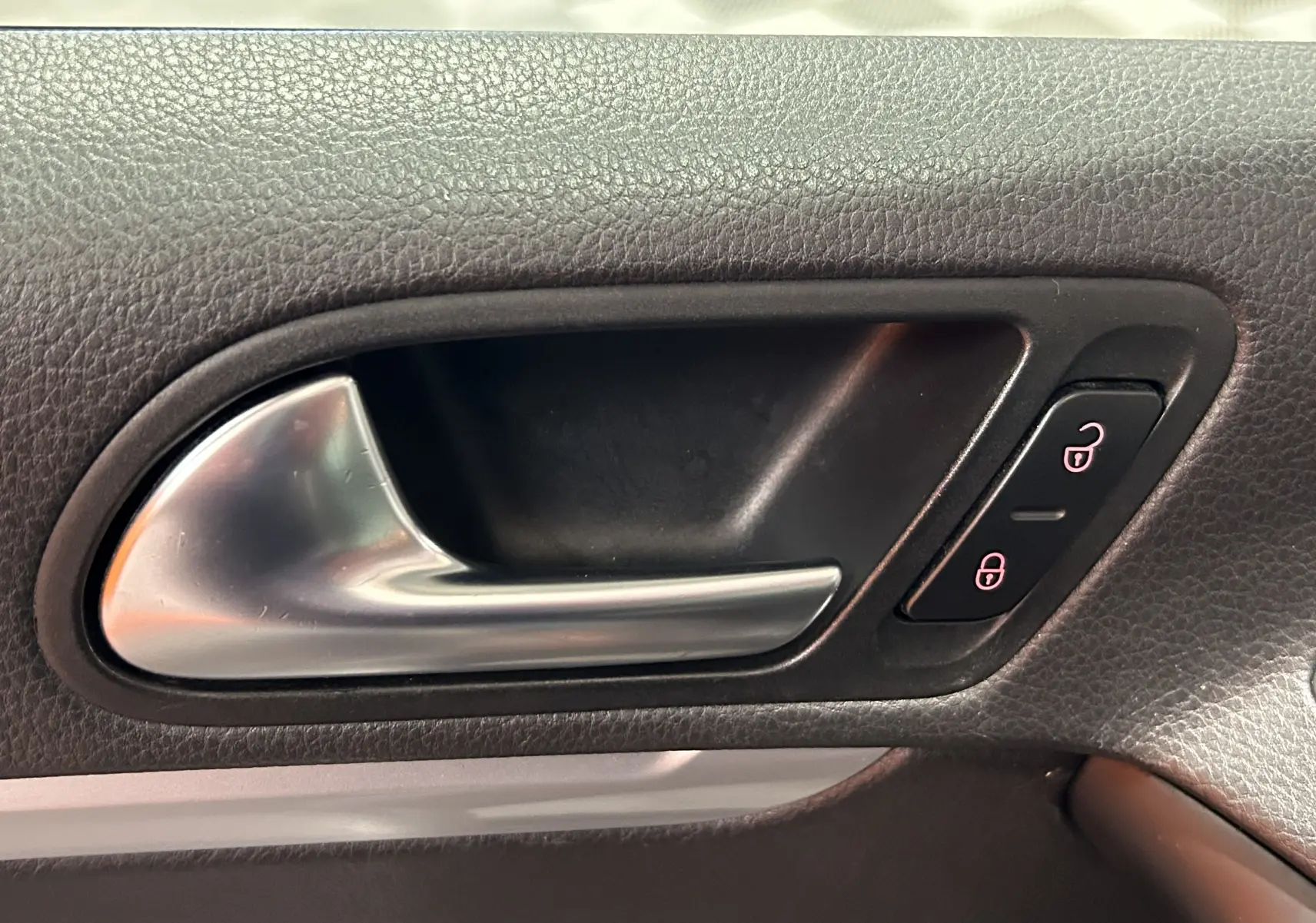 Poignée intérieure de porte côté gauche en métal brossé sur Volkswagen Tiguan noir métal 2015.