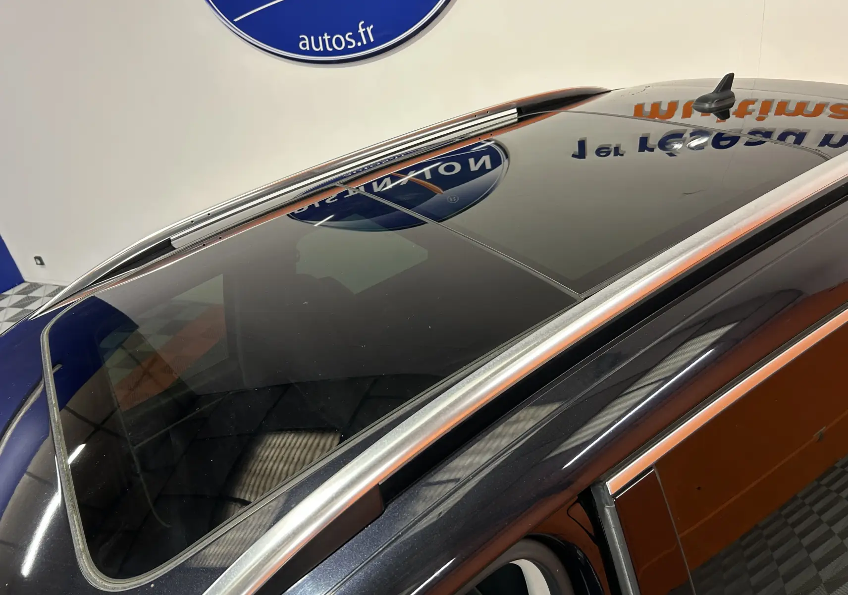 Vue plongeante sur le toit ouvrant panoramique d'un Volkswagen Tiguan noir métal, soulignant ses barres de toit argentées.