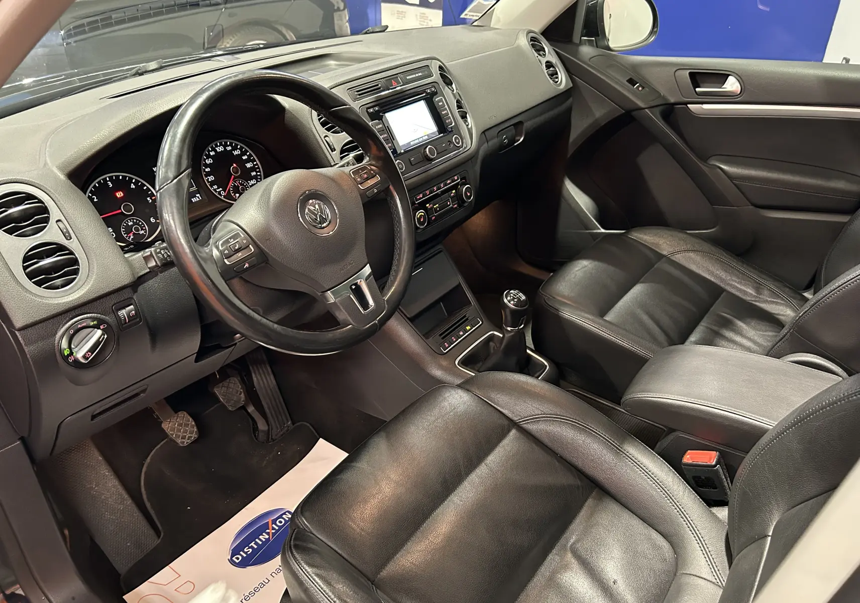 Intérieur noir cuir du Volkswagen Tiguan 2015 vu côté conducteur, avec volant multifonction et boîte manuelle.