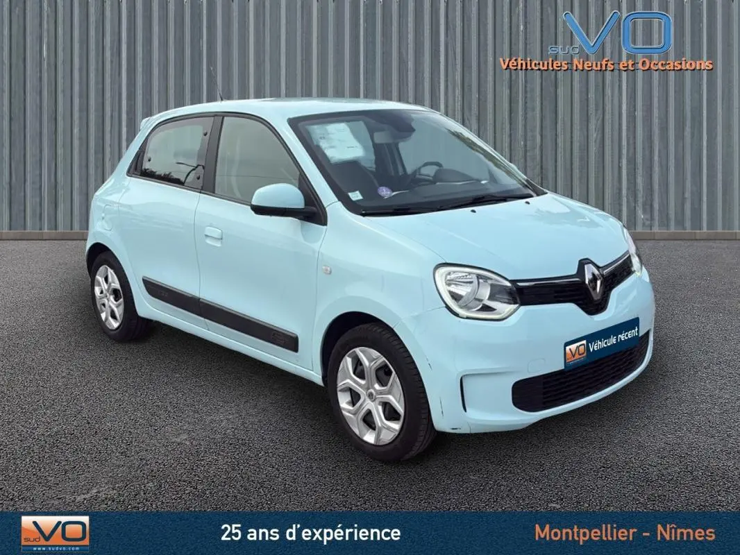 Renault Twingo III bleu clair vue 3/4 avant droit sur fond gris avec logo VO sur plaque avant.