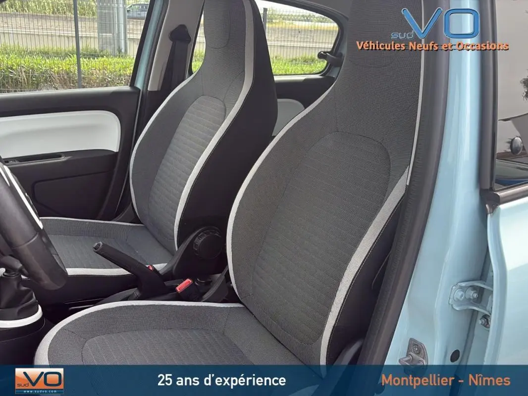 Vue intérieure côté gauche de la Renault Twingo III bleu clair, montrant les sièges avant gris avec contours clairs.
