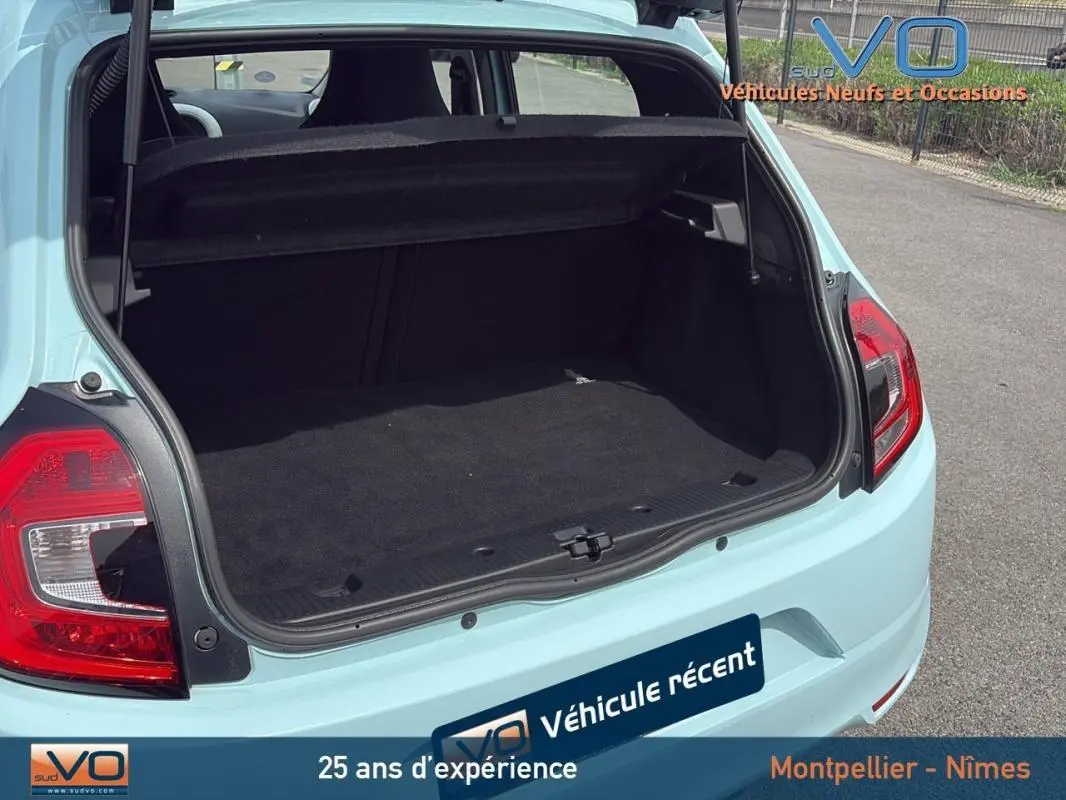 Coffre ouvert vu de l'arrière d'une Renault Twingo III bleu clair, montrant l'espace de chargement vide.