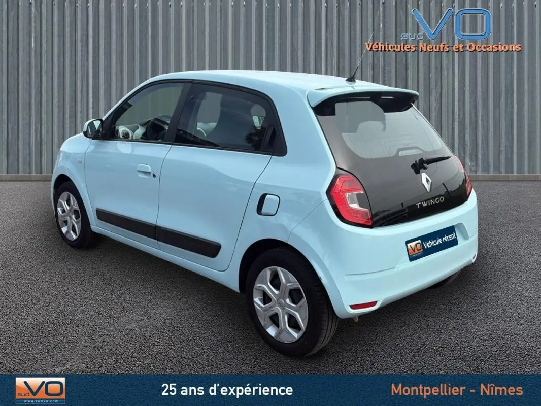 Vue 3/4 arrière droite d'une Renault Twingo III bleu clair, avec vitres teintées et jantes alliage.