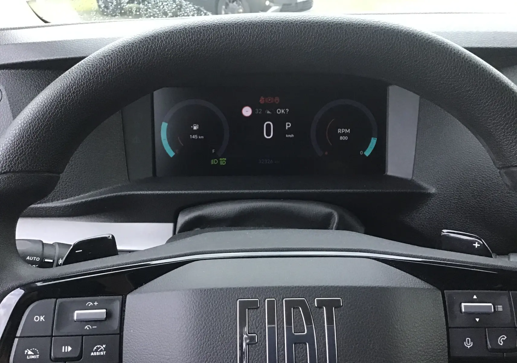 Vue rapprochée du volant noir FIAT avec tableau de bord numérique affichant vitesse et RPM.