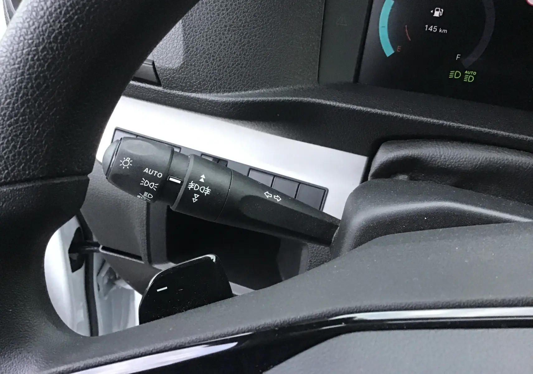 Détail du commodo d'éclairage à gauche du volant dans l'habitacle du Fiat Scudo Fourgon blanc 2024.