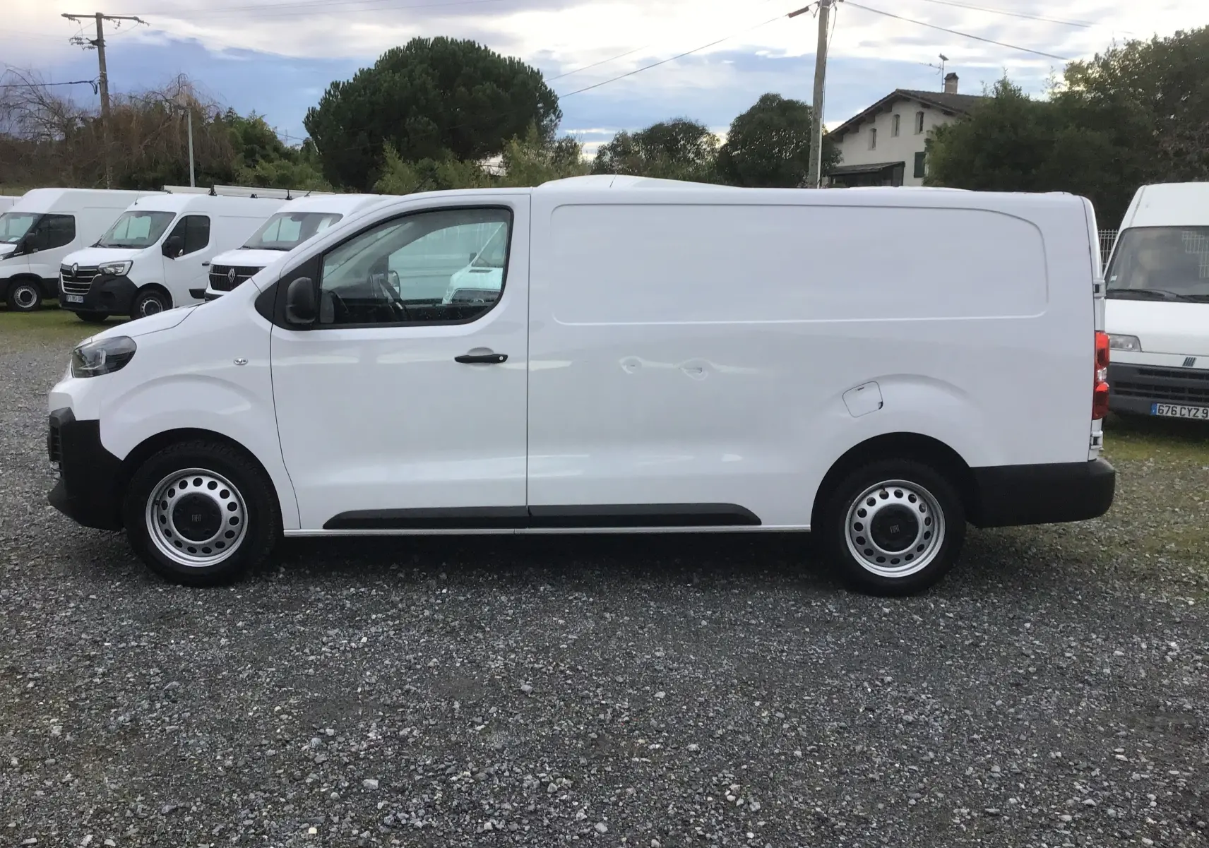Fiat Scudo Fourgon blanc vue de profil côté gauche, fourgon utilitaire avec garde au sol réhaussée et jantes acier.