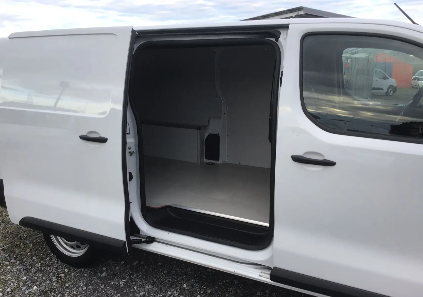 Vue latérale gauche d'un FIAT Scudo Fourgon blanc 2024 avec porte coulissante ouverte dévoilant l'espace de chargement vide.