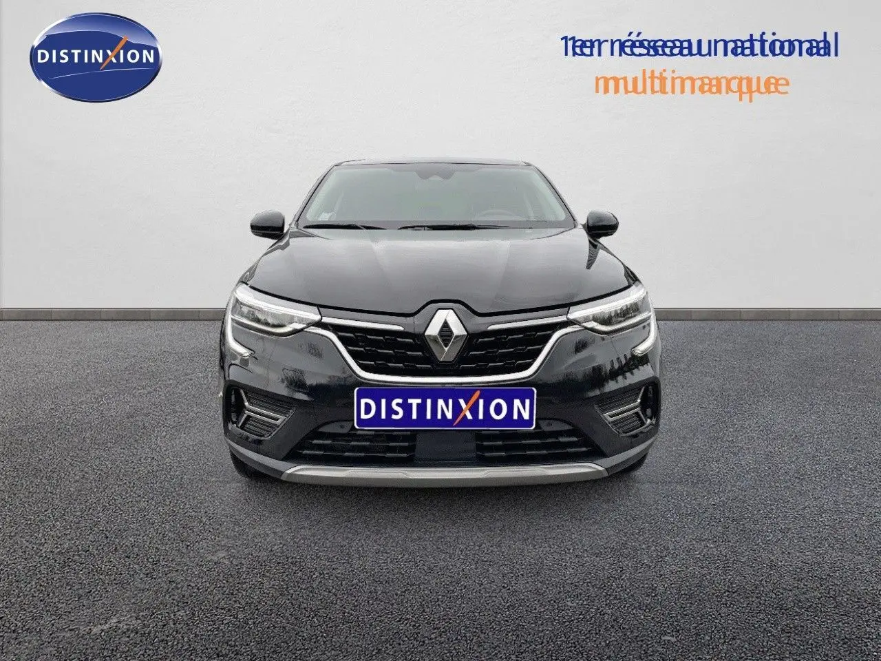 Vue frontale d'une Renault Arkana noire 2023 avec calandre chromée et phares LED allumés sur fond neutre.