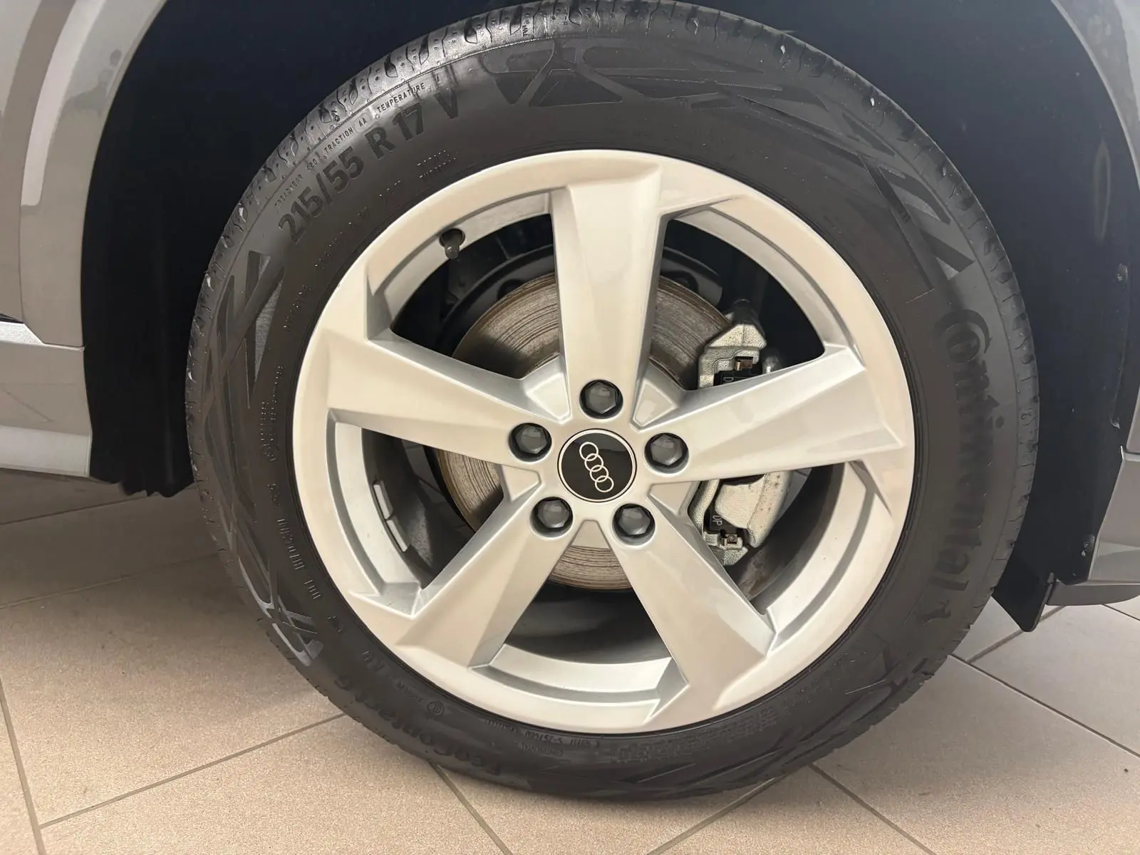 Gros plan sur la roue avant gauche de l'Audi Q2 35 TFSI S Line 2026 en gris Daytona avec jante argentée cinq branches.