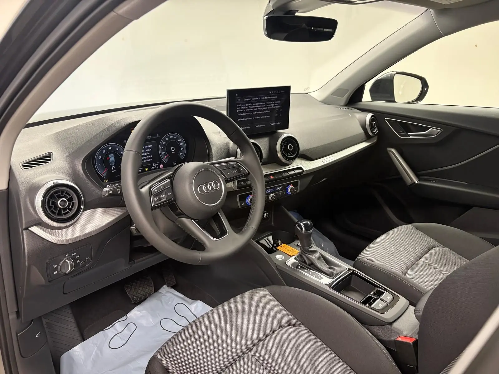 Vue intérieure côté conducteur de l'Audi Q2 35 TFSI 150 S tronic 7 S line avec tableau de bord moderne et écran central.