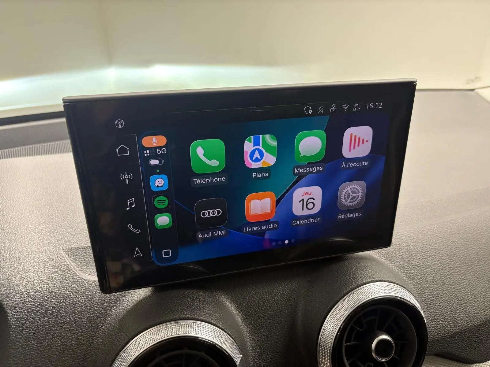 Écran tactile central de l’Audi Q2 35 TFSI S Line 2026 affichant l’interface Apple CarPlay sur tableau de bord noir.