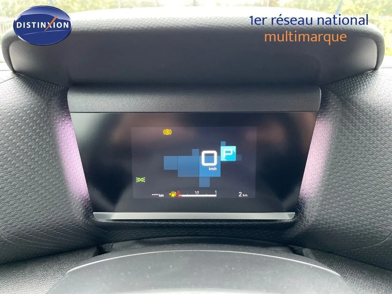 Affichage numérique du tableau de bord de la Citroën C4 blanche métal 2024, indiquant la vitesse à 0 km/h et le mode parking.