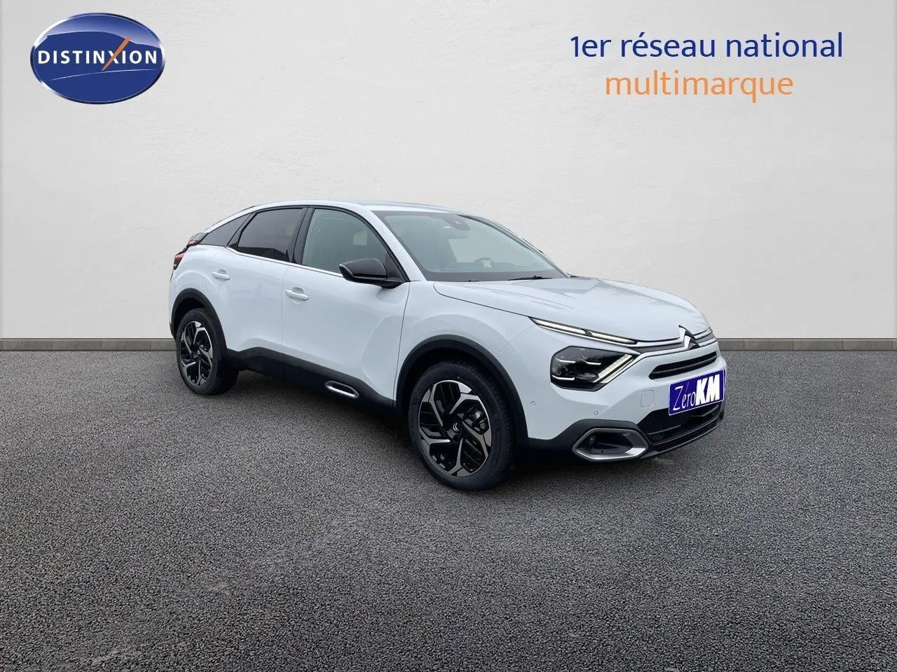 Citroën C4 blanc métal vue 3/4 avant droit avec jantes noires et détails noirs contrastants.
