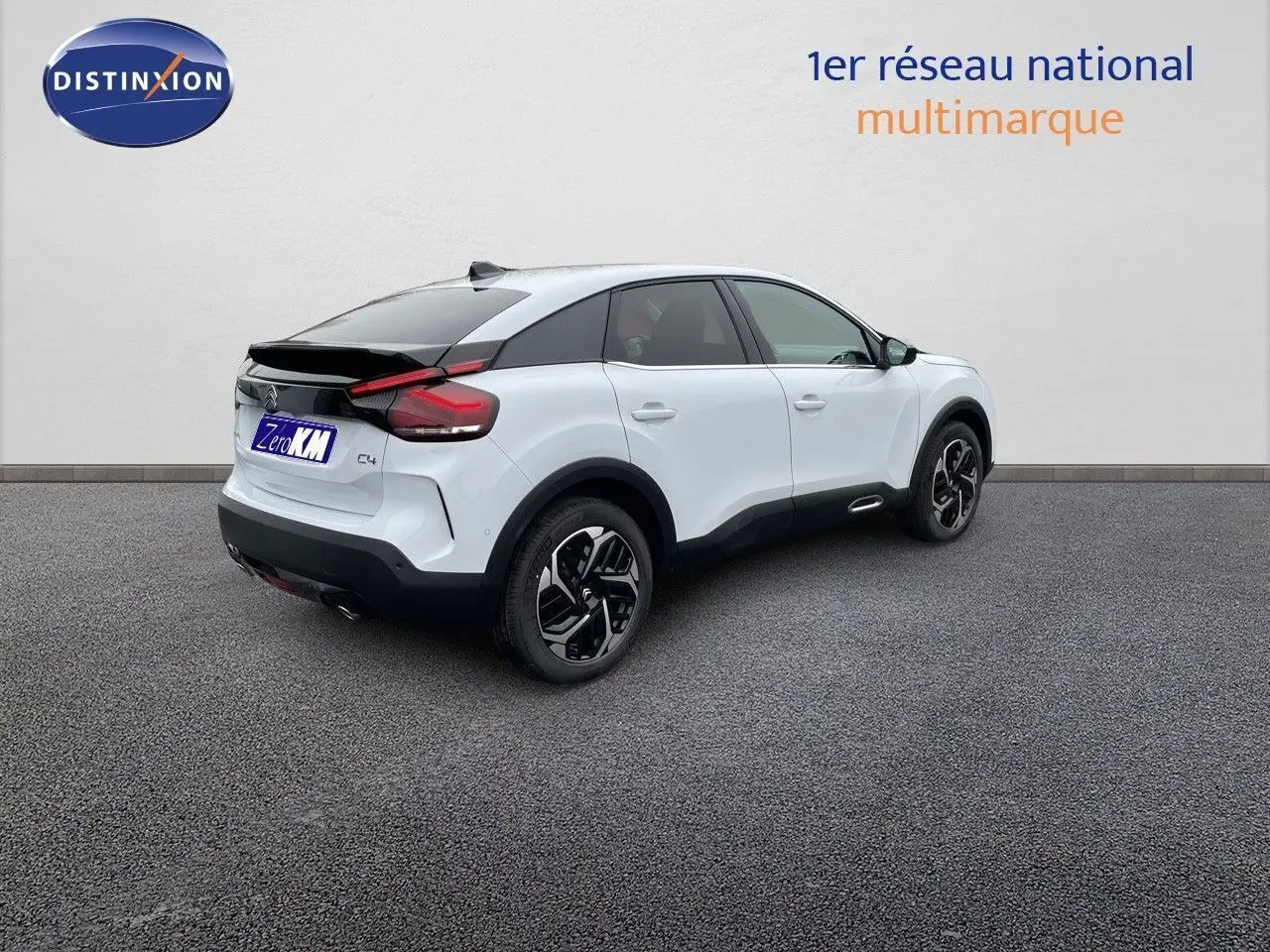 Citroën C4 blanc métal vue 3/4 arrière droit, toit noir contrasté et jantes noires bicolores.
