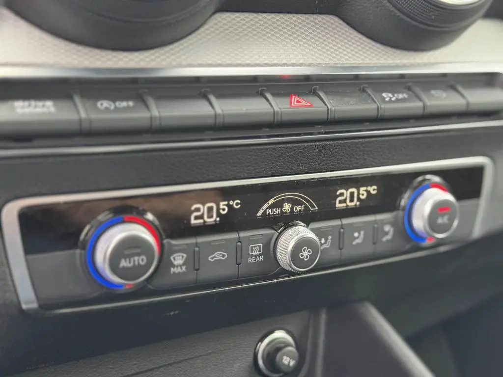 Détail de la console centrale avec commandes de climatisation automatique bi-zone de l'Audi Q2 2022 noire.