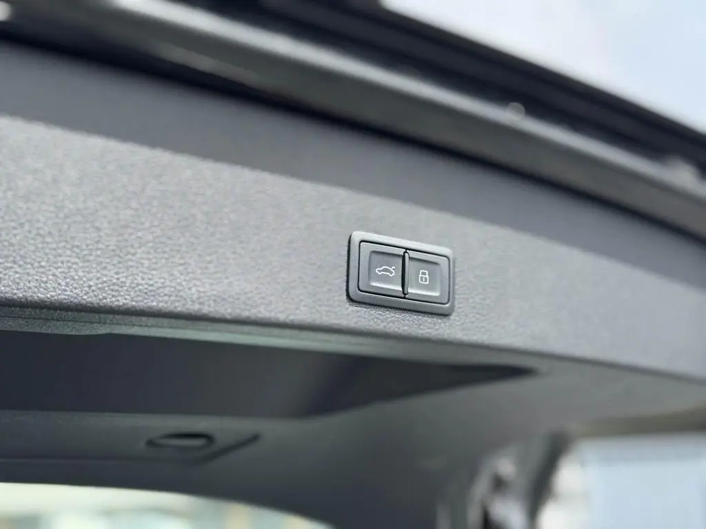 Boutons de fermeture et verrouillage du coffre sur le hayon intérieur d'un Audi Q2 noir 2022 Design.