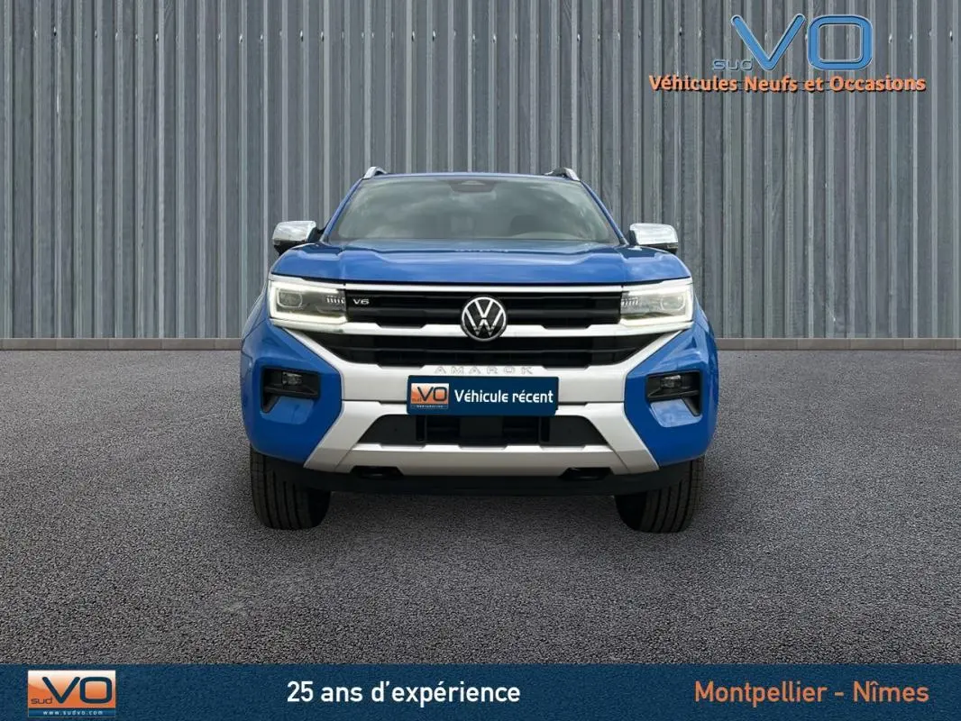 Vue frontale du Volkswagen Amarok Simple Cabine bleu 2025 avec calandre noire et détails argentés, jantes alliage 21 pouces visibles.