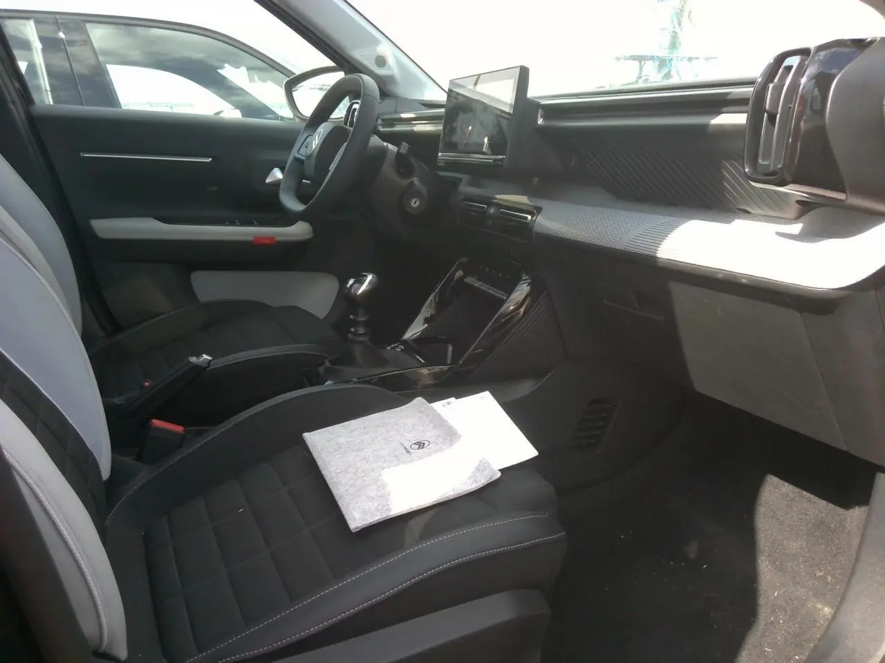 Vue intérieure côté conducteur de la Citroën C3 Turbo 100 Max 2025, sièges noirs et gris, écran tactile central visible.