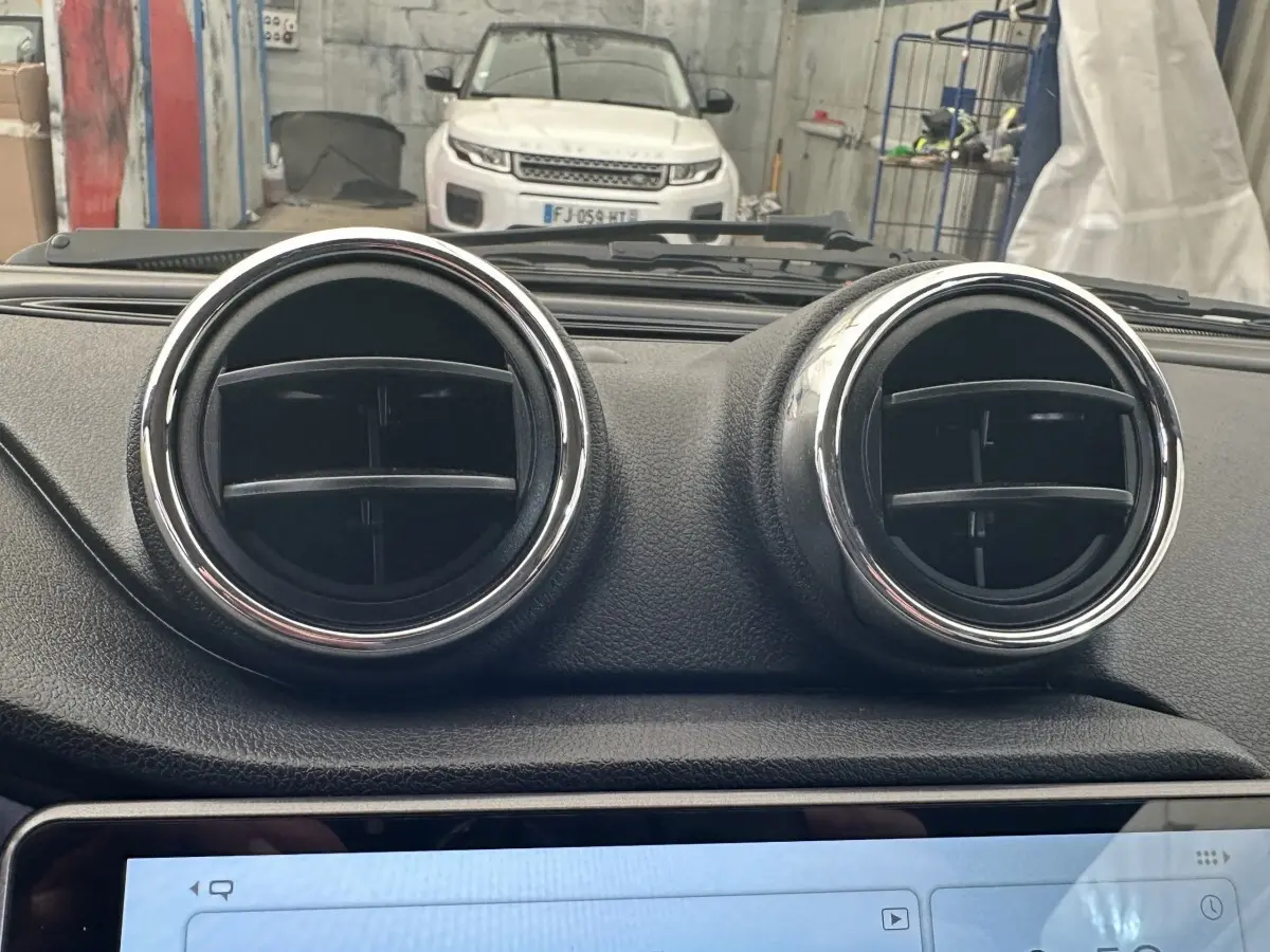 Vue intérieure centrée sur les deux aérateurs ronds du tableau de bord d'une Aixam Ambition 0.5 City GTO blanche.