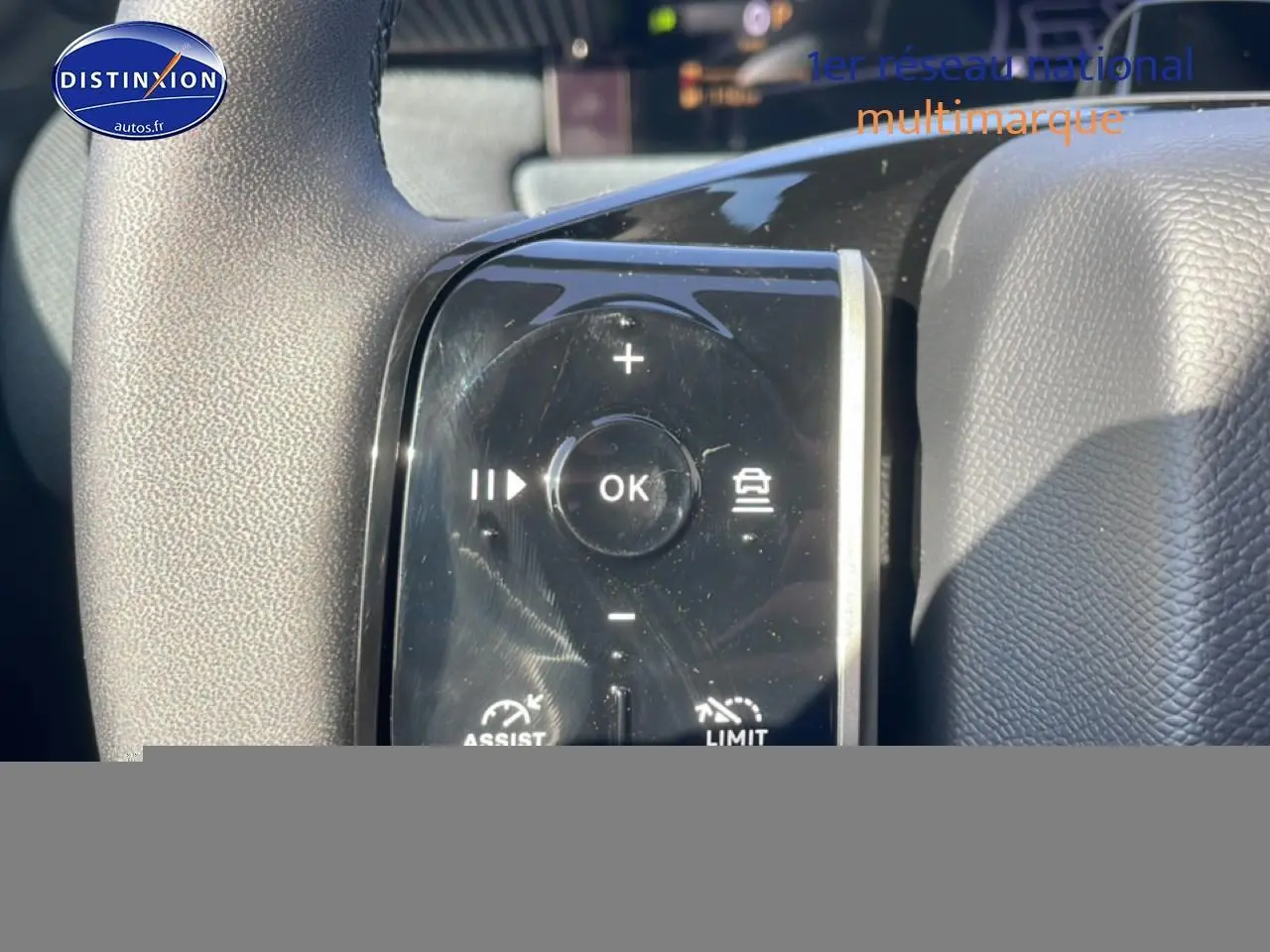 Gros plan sur les commandes au volant noir du Citroën C5 Aircross blanc, avec boutons multifonctions et régulateur de vitesse.