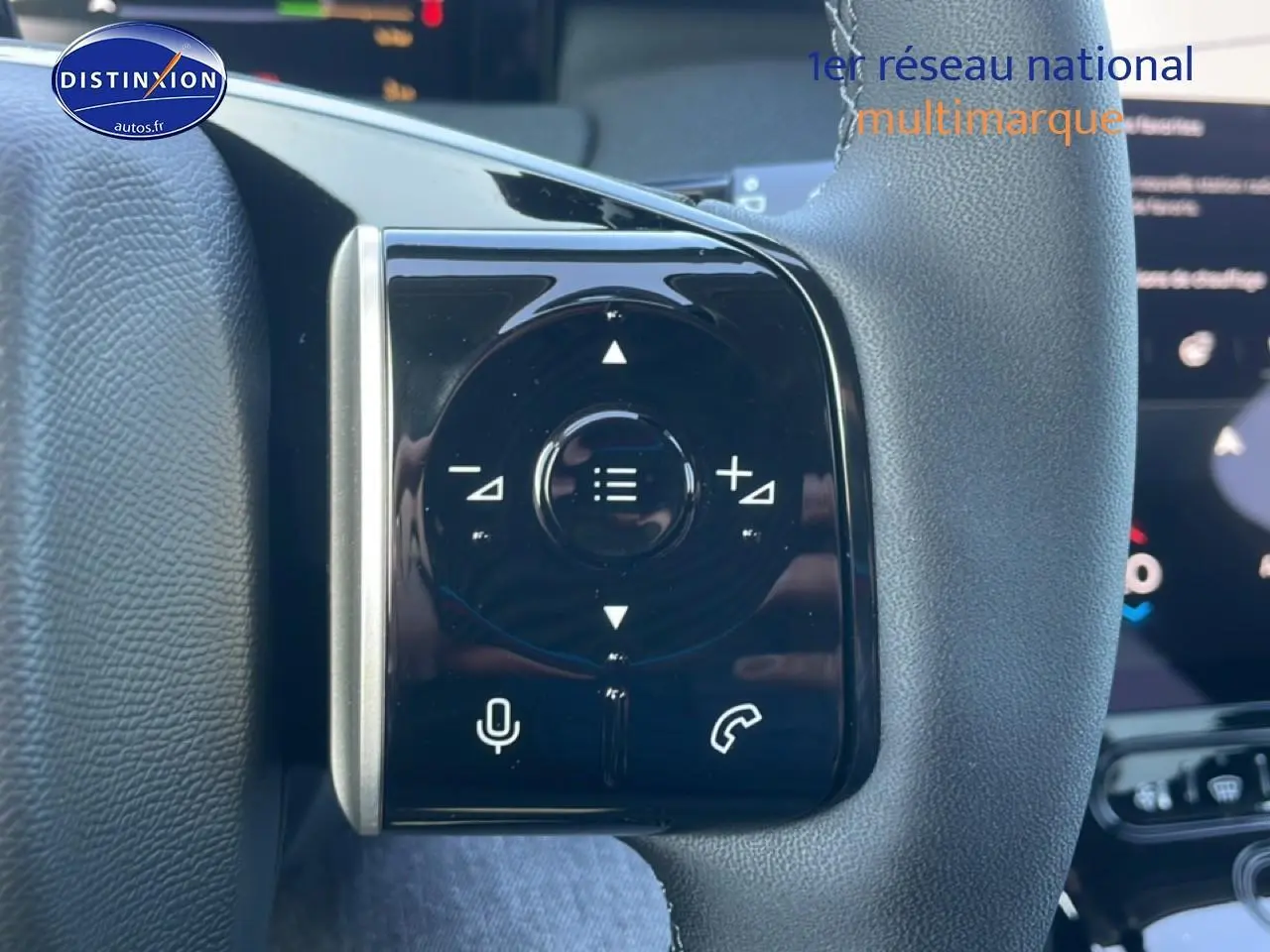 Gros plan sur les commandes noires du volant du Citroën C5 Aircross hybride blanc, avec touches multifonctions.