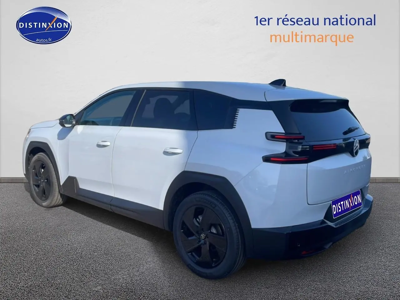 Vue 3/4 arrière droite d'un Citroën C5 Aircross blanc avec jantes noires et vitres arrière teintées.
