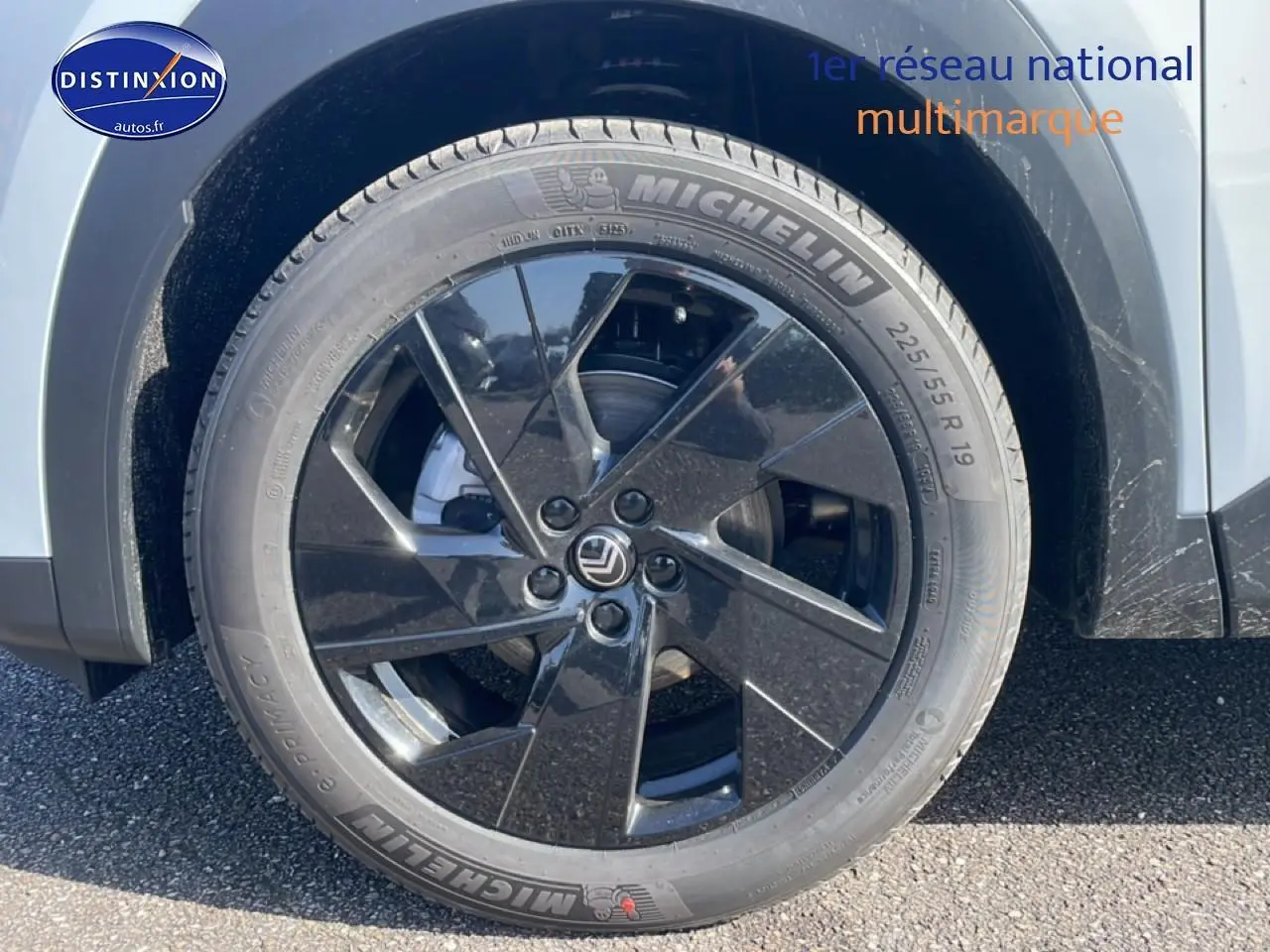 Gros plan sur la roue arrière droite noire et jante 19 pouces du Citroën C5 Aircross blanc 2026 hybride.