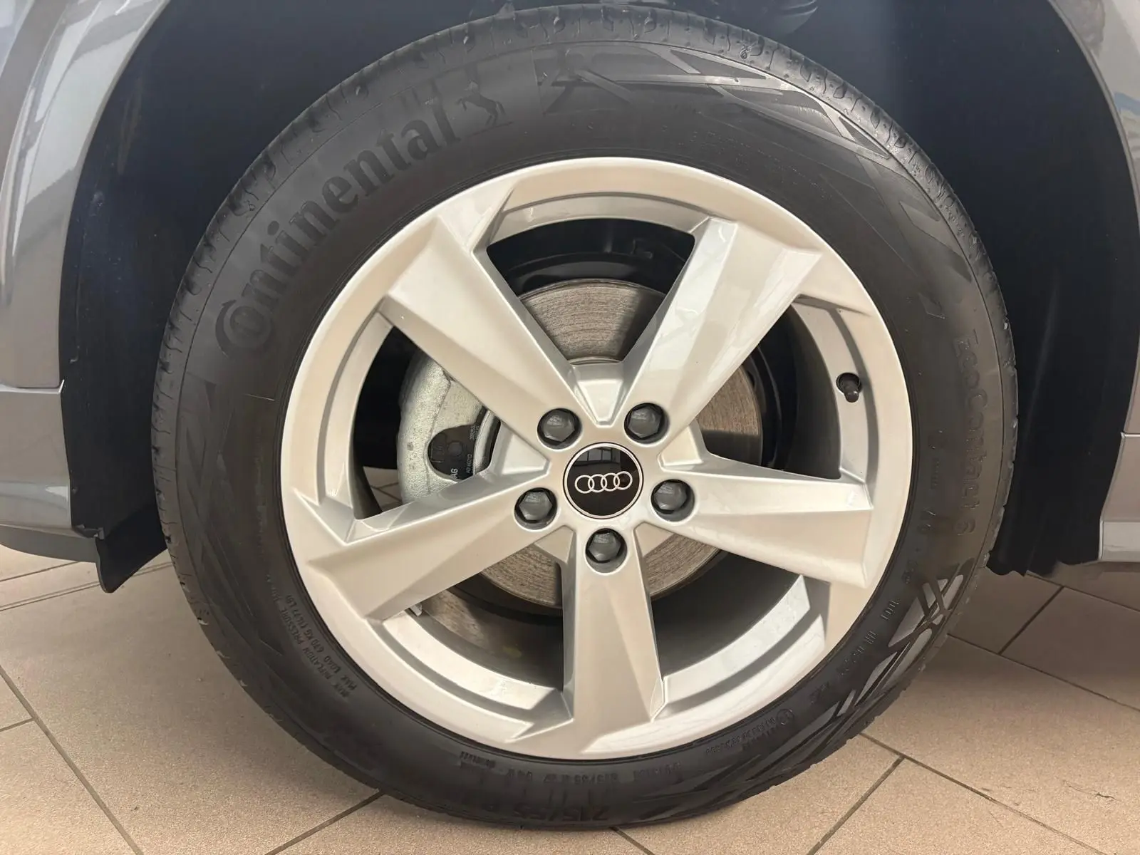 Gros plan sur la roue avant gauche de l'Audi Q2 35 TFSI S Line gris Daytona avec jante alliage cinq branches.