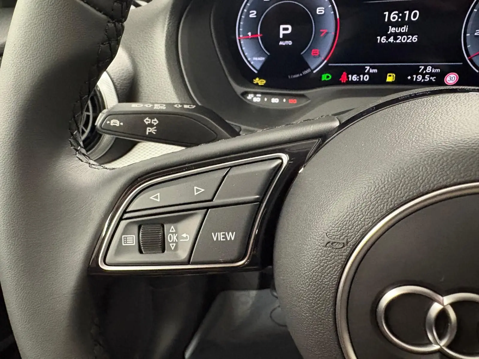 Gros plan sur le volant côté gauche de l'Audi Q2 35 TFSI 2026 avec commandes intégrées et tableau de bord numérique.