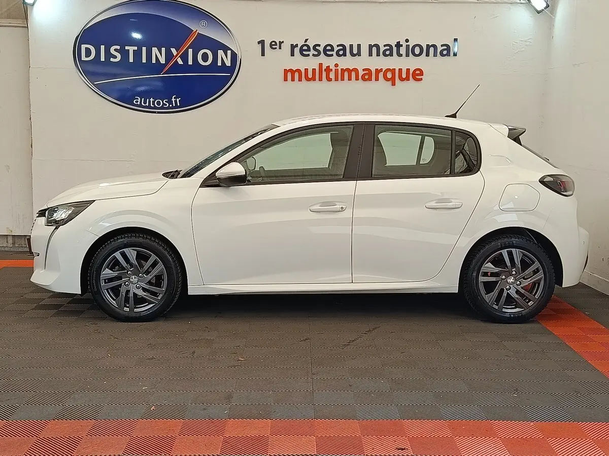 Profil droit d'une Peugeot 208 blanche 2021 PureTech 75 S&S Active Business, avec jantes alliage et feux arrière foncés.