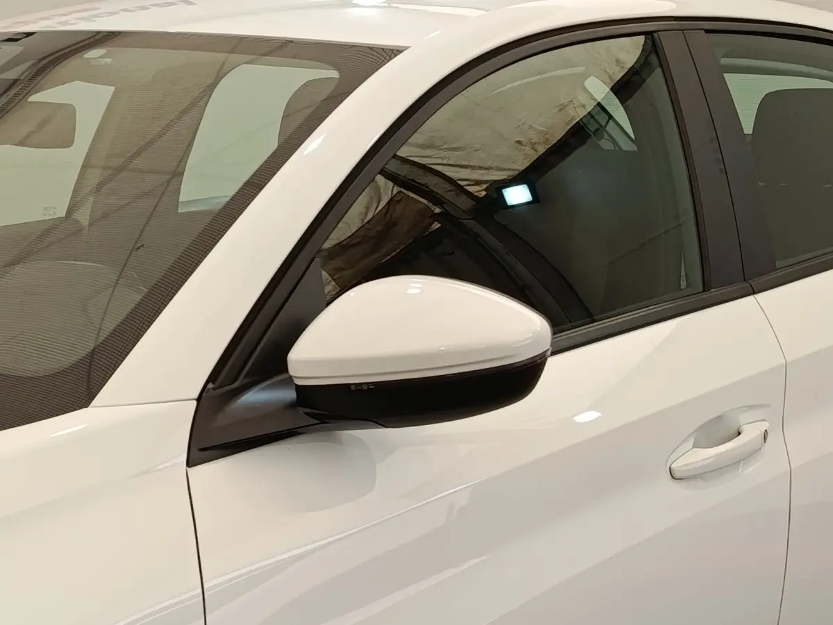 Vue rapprochée du rétroviseur droit blanc et de la portière avant droite d'une Peugeot 208 blanche.