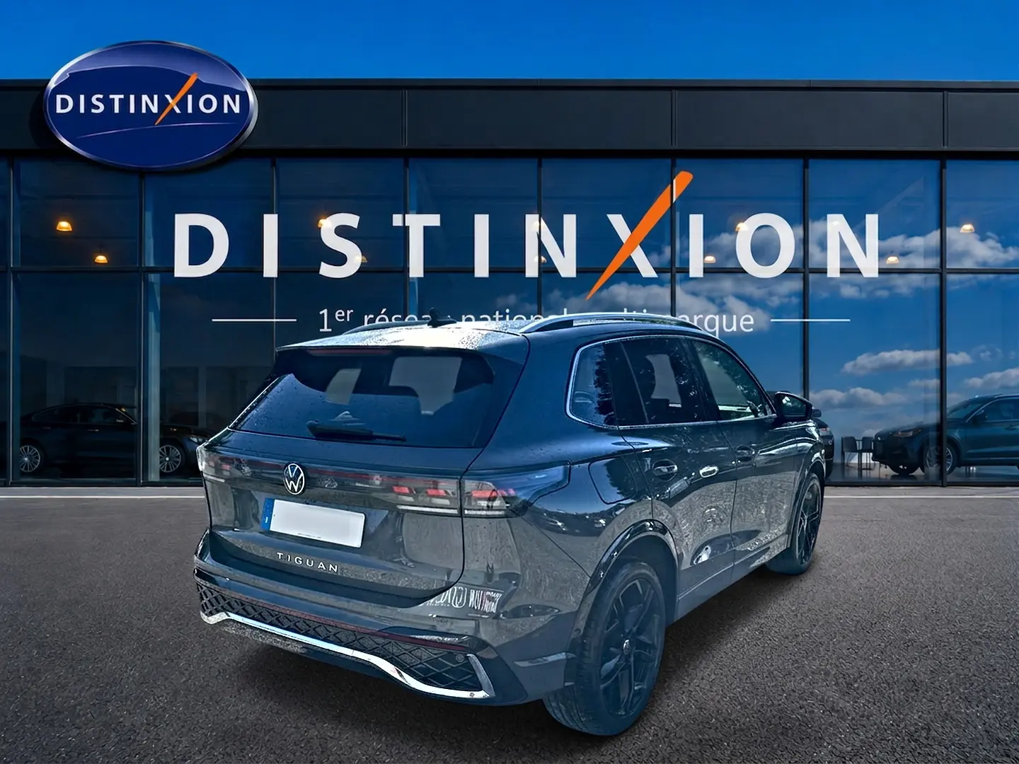 Volkswagen Tiguan 2.0 TDI gris dauphin en 3/4 arrière droit, avec jantes noires et feux LED distinctifs.