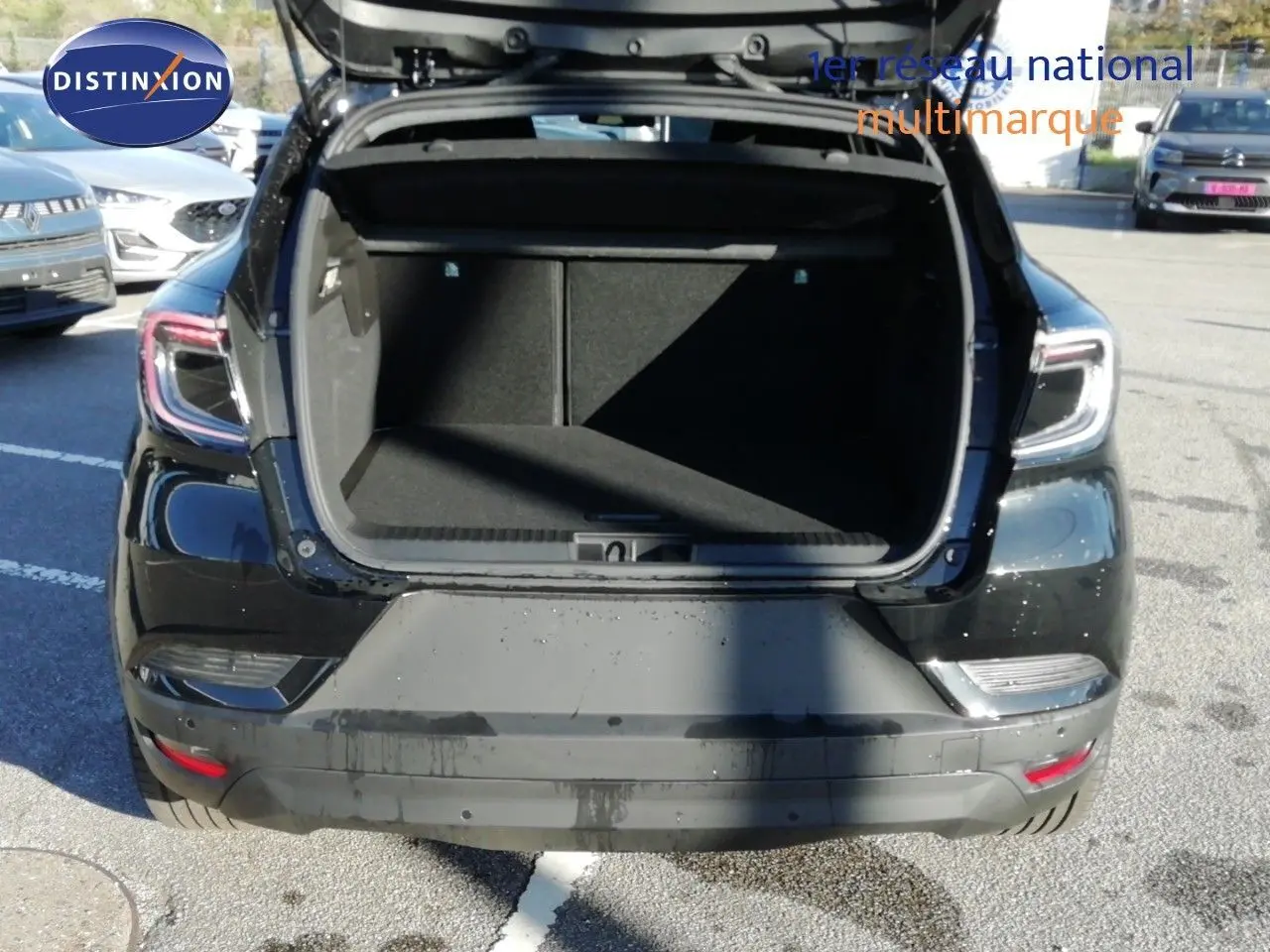 Vue arrière d'un Renault Captur noir étoile métal 2026 avec coffre ouvert, montrant l'espace de chargement vide.