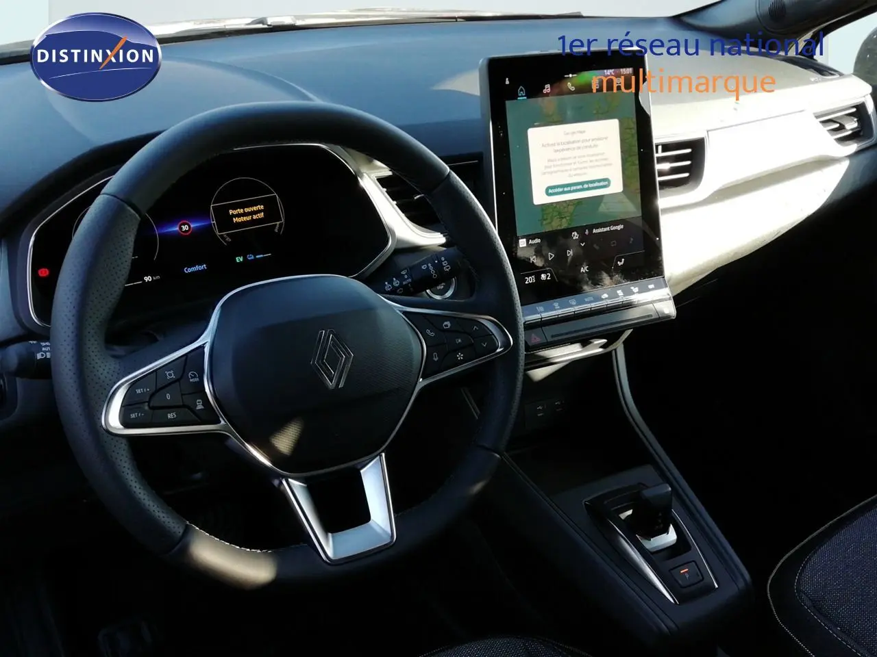 Vue intérieure centrée sur le volant et l’écran tactile du Renault Captur E-Tech hybride, ambiance noire et moderne.