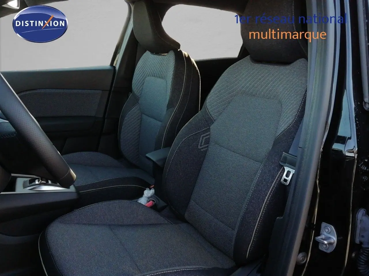 Vue intérieure côté conducteur du Renault Captur E-Tech hybride 2026, sièges tissu gris avec surpiqûres contrastées.