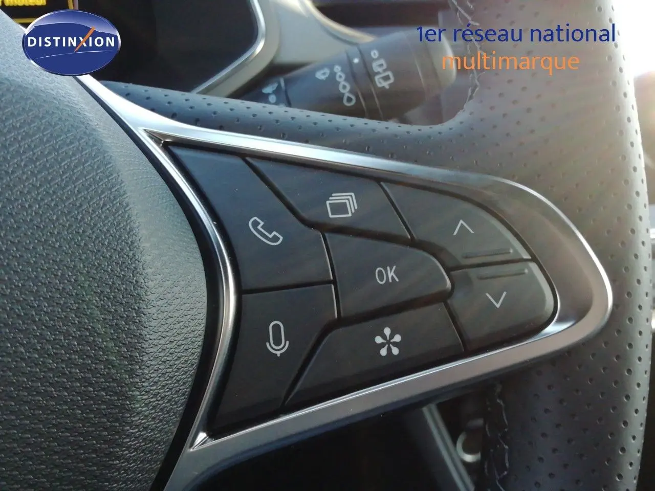 Gros plan sur les commandes au volant perforé du Renault Captur noir étoile métal, version hybride 2026.