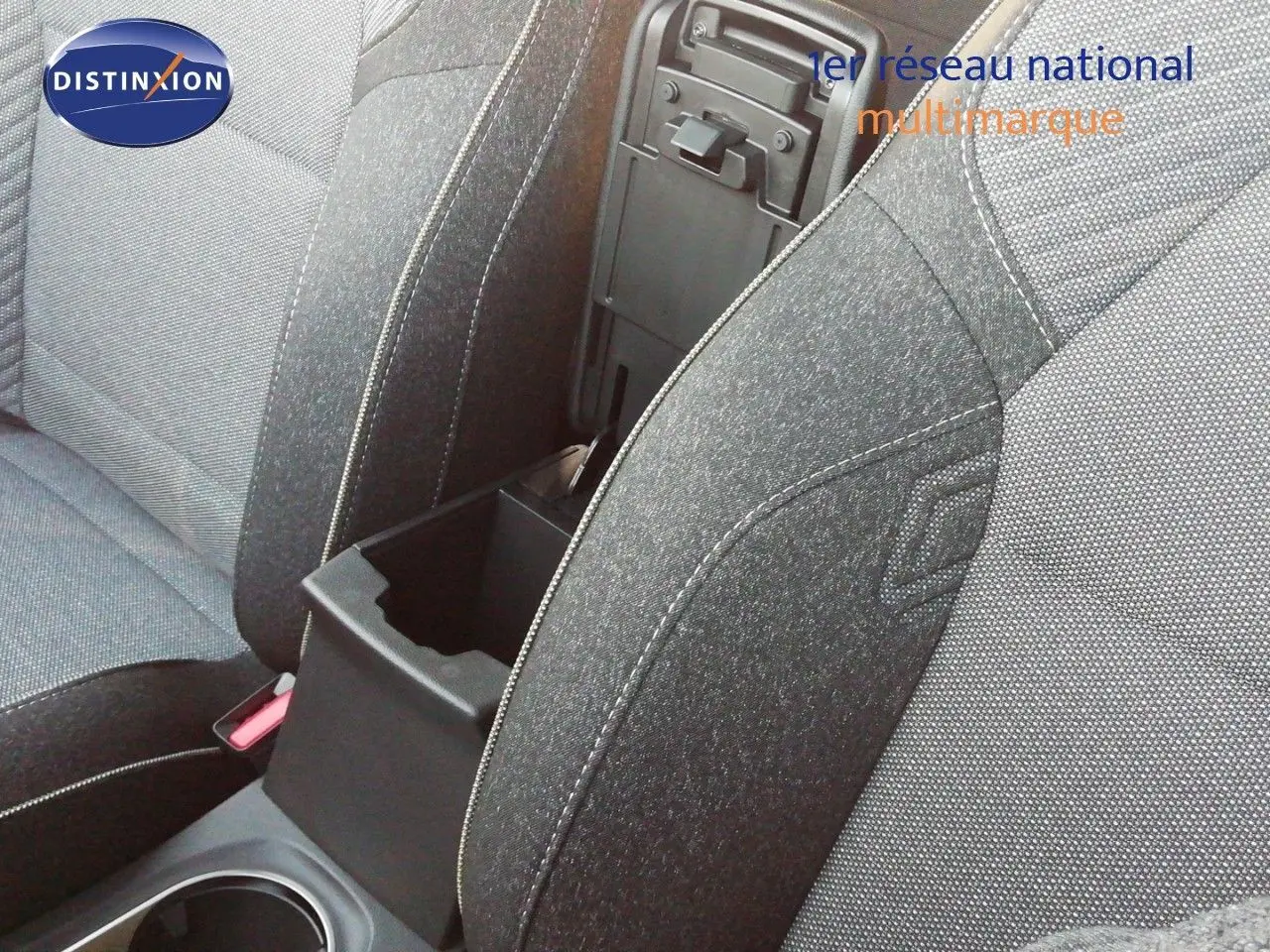 Gros plan sur l'accoudoir central ouvert entre les sièges avant en tissu gris du Renault Captur E-Tech hybride 2026.