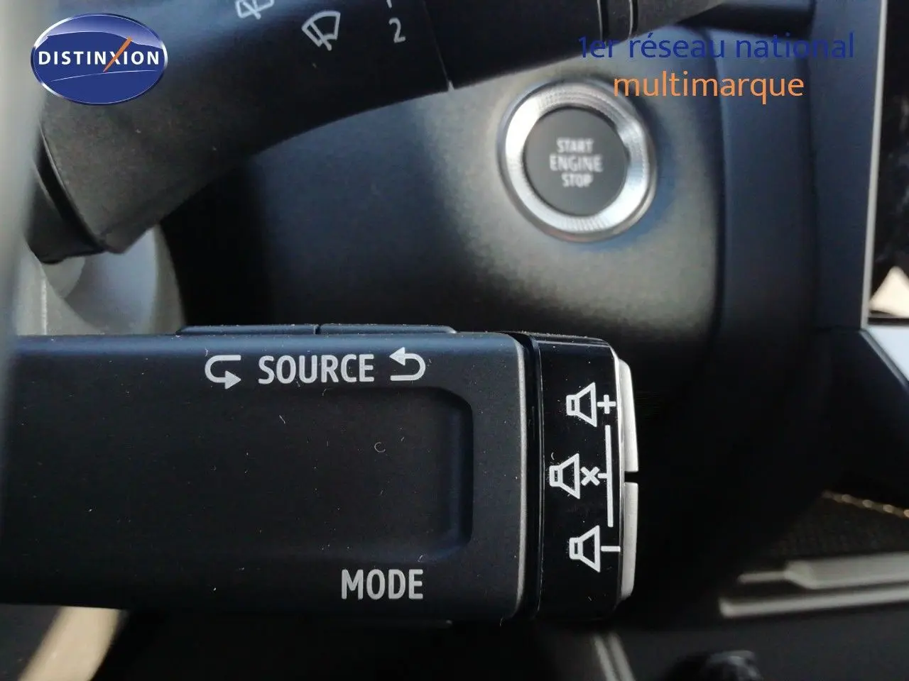 Gros plan sur la commande au volant du Renault Captur noir Étoile Métal, avec bouton start engine stop en arrière-plan.