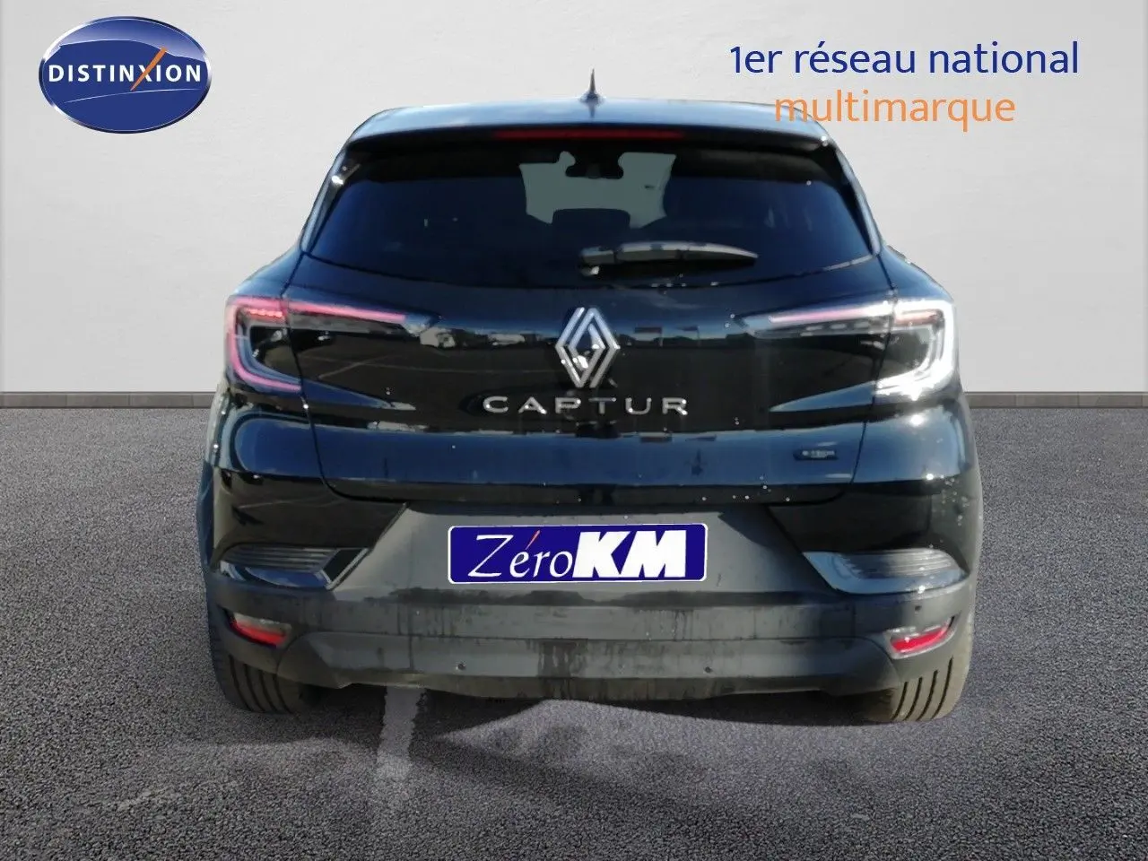 Vue arrière d'un Renault Captur noir étoile métal, version hybride, avec feux arrière LED et logo central visible.