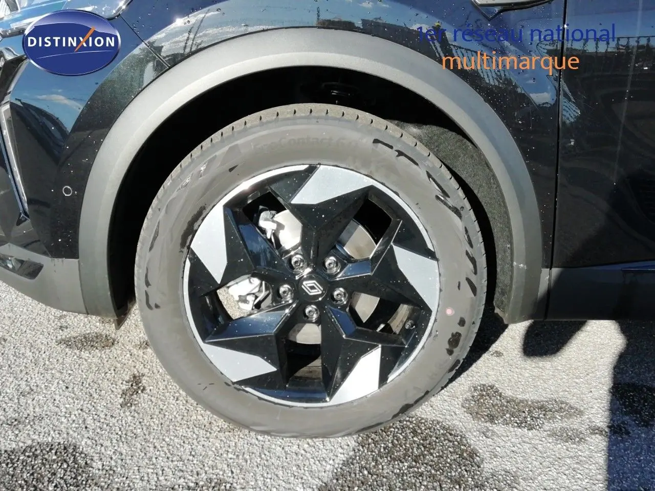 Gros plan sur la roue avant gauche du Renault Captur noir étoile métal, avec jante bi-ton noire et argentée.