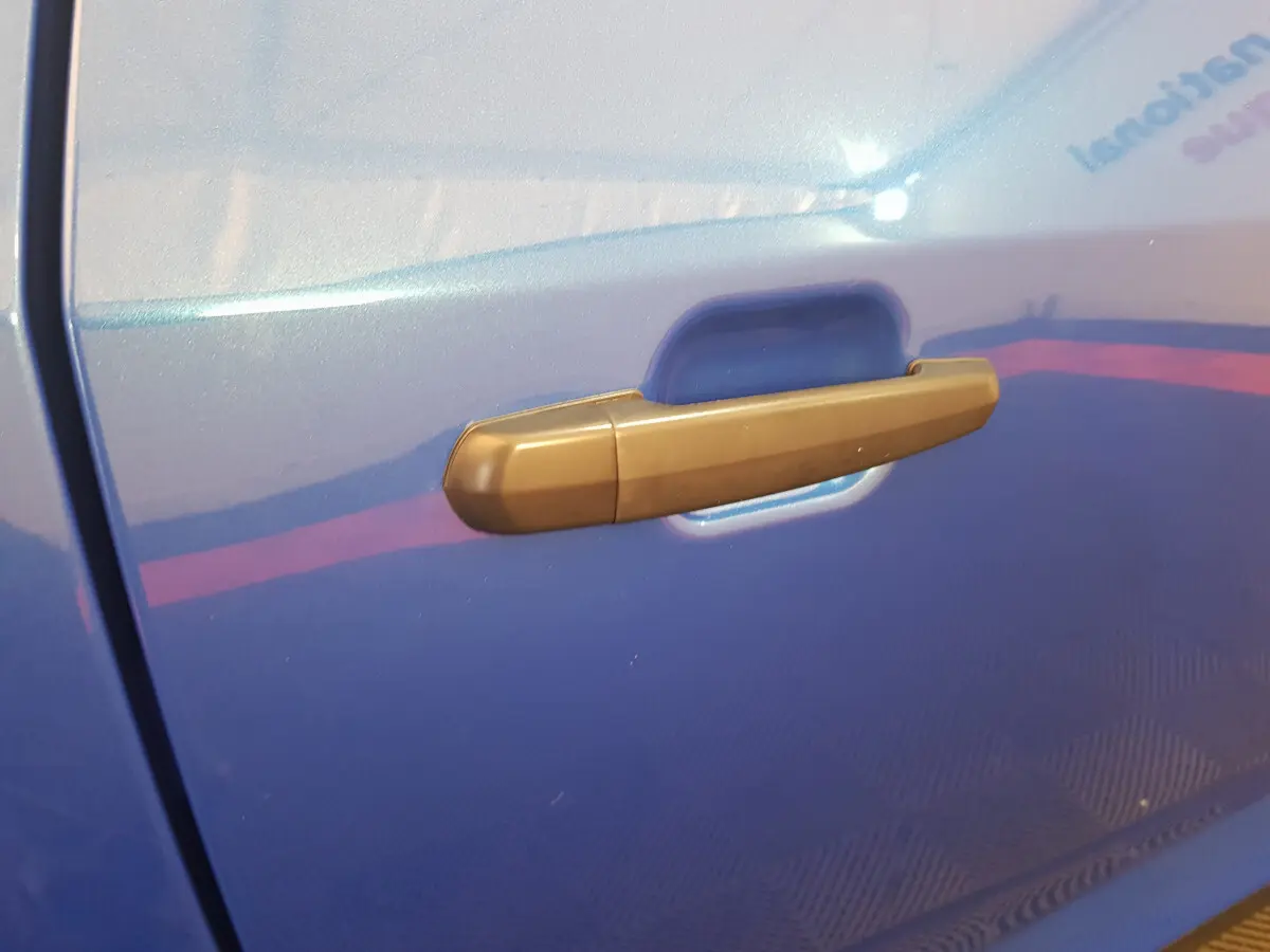 Poignée de porte côté gauche sur une Aixam Ambition 0.5 City Sport bleu 2026 avec finition mate.