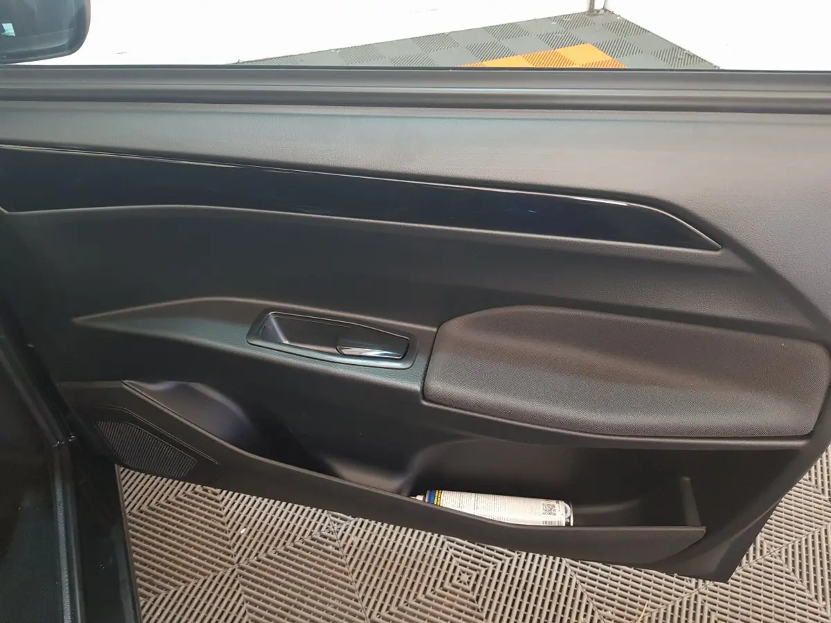 Vue intérieure de la porte côté conducteur de l'AIXAM AMBITION 0.5 CITY SPORT 2026, avec poignée et rangement noir.