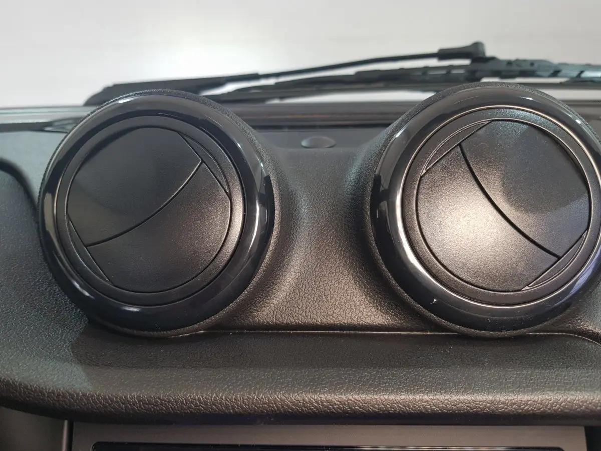 Détail intérieur montrant les deux aérateurs ronds noirs du tableau de bord de l'AIXAM AMBITION 0.5 CITY SPORT bleu 2026.