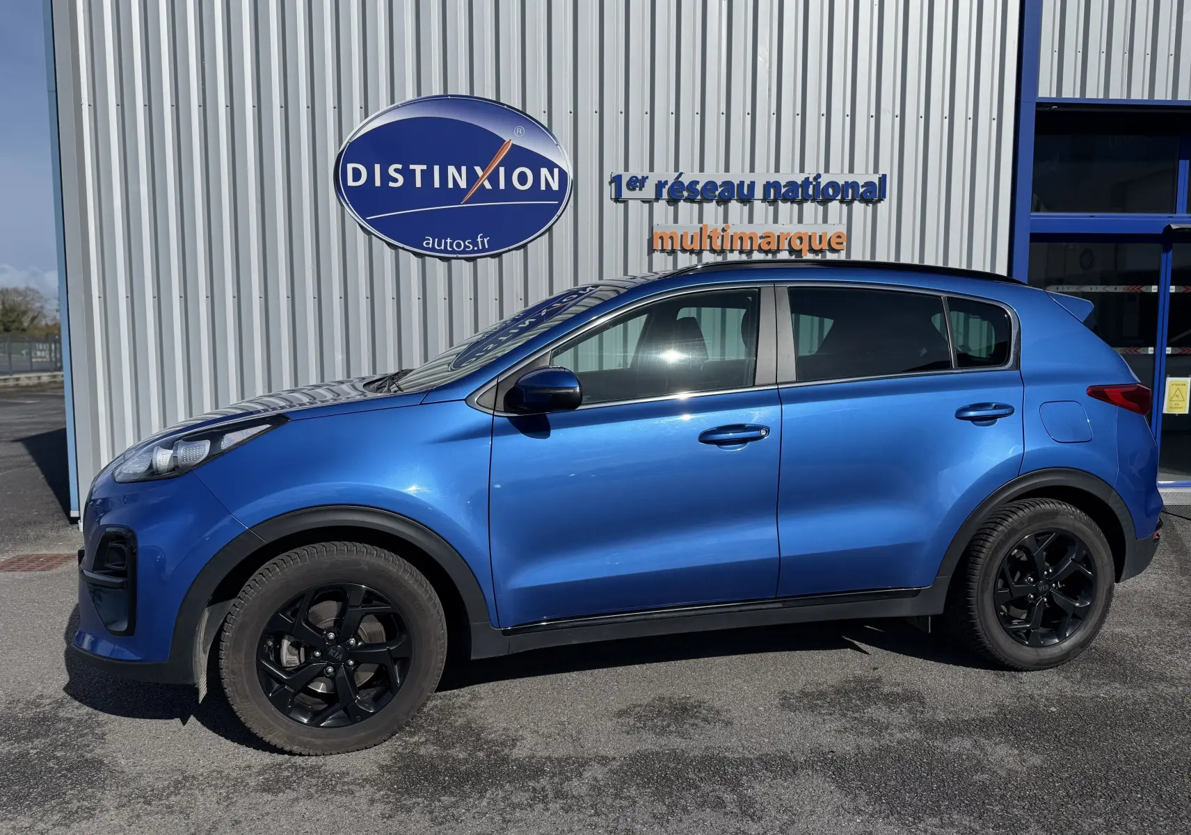 Vue de profil côté gauche du Kia Sportage 1.6 CRDI 136 Black Edition bleu avec jantes noires et détails noirs contrastants.