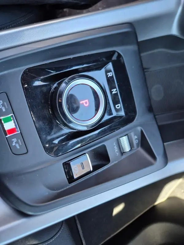 Vue rapprochée de la molette de sélection de vitesse et commandes centrales noires de l'Alfa Romeo Tonale bleu 2025.