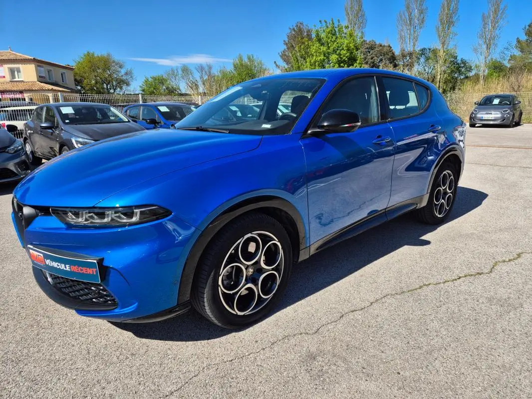 Vue 3/4 avant droite d'un Alfa Romeo Tonale bleu avec jantes alliage 18 pouces et rétroviseurs noirs brillants.