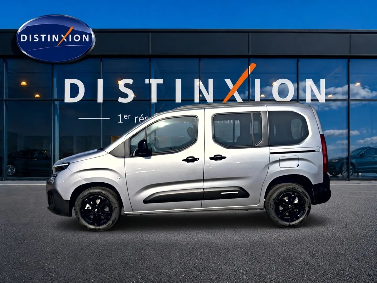 Profil droit du Citroën Berlingo 2026 gris acier avec jantes noires et barres de toit visibles.