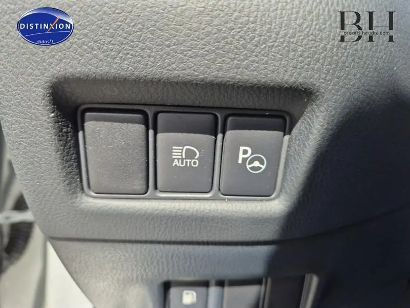 Gros plan sur les boutons de commande d'assistance au stationnement et d'éclairage automatique du Toyota C-HR gris aluminium 2019.