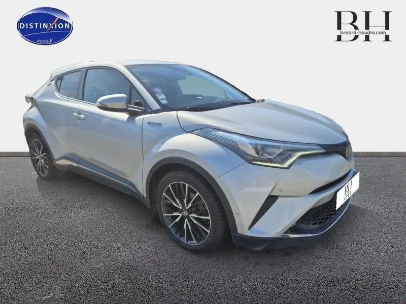 Toyota C-HR gris aluminium en 3/4 avant droit avec jantes alliage et lignes anguleuses distinctives.