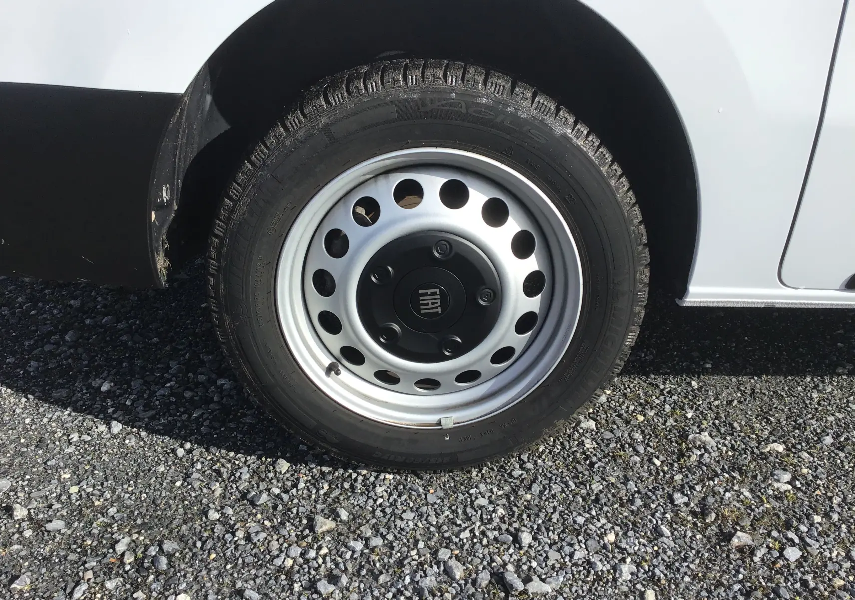 Gros plan sur la roue avant droite blanche du FIAT Scudo Fourgon 2024 avec jante acier et logo FIAT central.